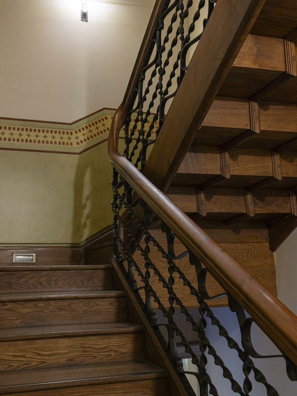 La escalera original de madera con balaustres de hierro forjado dentro de Casa Botines